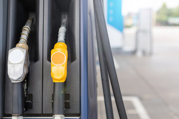 Fuel nozzle in Petrol station. Soft focus on blur day light background with space for text. Energy or transportation concept