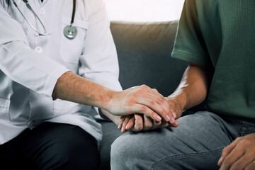 Doctor is holding the hand of the patient by giving him confidence in the doctor.