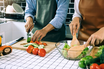 Young asian couple is preparing healthy food together and preparing for a happy lunch.