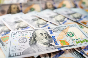 Hundred dollar bill close-up stands on other hundred dollar bills