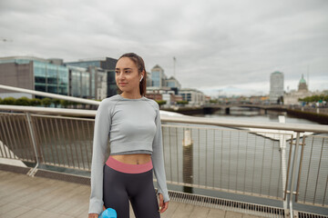 Beautiful Fitness woman in sportswear have a rest after workout on city background