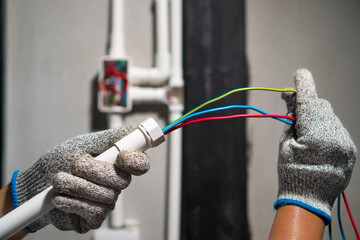 Electrician pulling wire into PVC Conduit