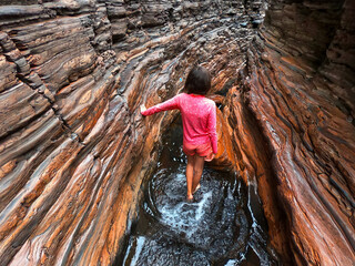 Australian woman hiking at spider walk at Hancock Gorge in Karijini National Park Western Australia