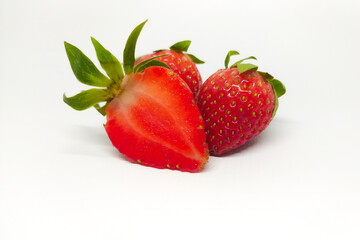 whole and sliced fresh strawberries isolated on white background