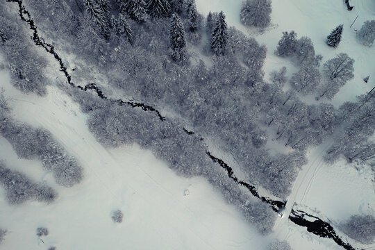 Winter Landschaft verschneite Bäume und Fluss von oben mit Drohne Schweiz