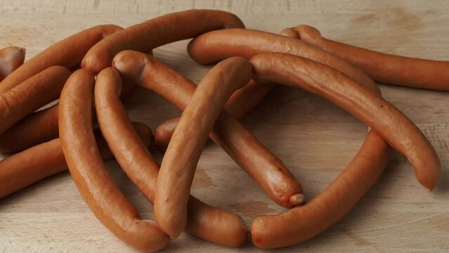 Thin pork sausages on the wooden cutting board