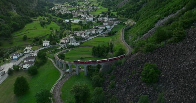 The Bernina Express Ttrain passes over the helical Brusio viaduct. Filmed in high quality with DJI Mavic 3 Cine.