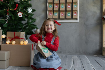 Happy child with handmade advent calendar gift package with candy, Christmas children's fan - obrazy, fototapety, plakaty