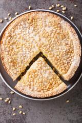 Traditional Tuscany pastry Italian cake torta della nonna or grandmother's cake closeup in the plate on the table. Vertical top view from above