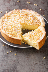 Italian Grandma's cake Torta della nonna Pine nut custard tart from Tuscany closeup in the plate on the table. Vertical