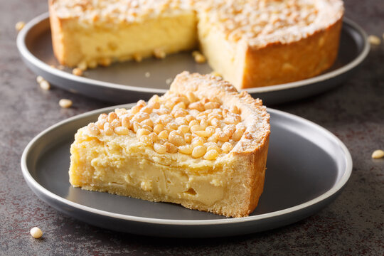 Italian cake covered with pine nuts known as torta della nonna closeup in the plate on the table. Horizontal