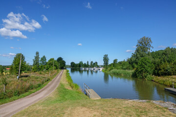 View of a canal with boats in an idyllic summer landscape