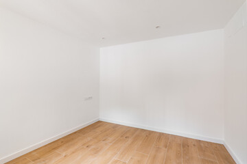 Empty room with laminate flooring and newly painted white wall in refurbished apartment. Repair and construction concept.