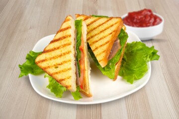 Delicious toasted sandwiches with cheddar cheese and bacon on the plate