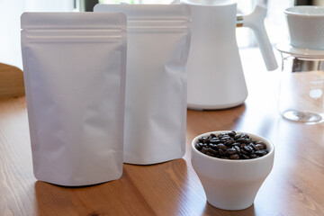 コーヒー豆のパッケージ2つとケトル、ドリッパー