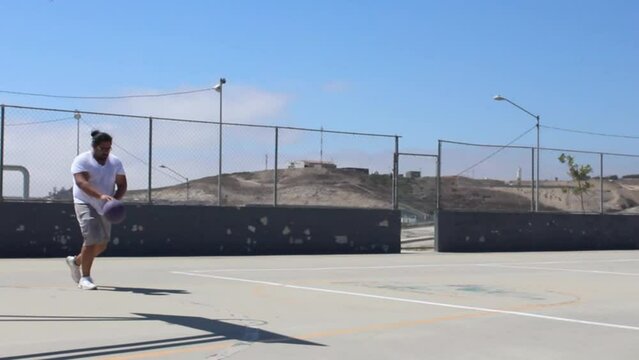 Overweight Hispanic Man Playing Basketball Outdoors. Sporty Fat Man