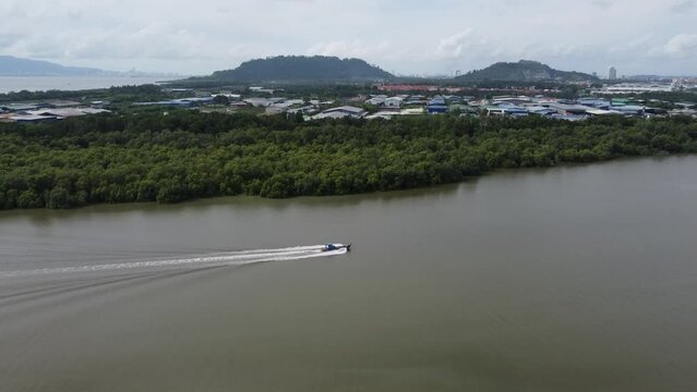 Aerial view fishing boat move at river. Background is Juru Industrial Park