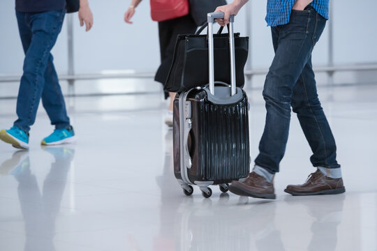 People carries luggage at the airport terminal and hurry up for check in on holiday or business trip.