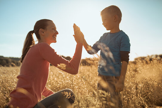Mother giving son high five. Parent child relationship concept