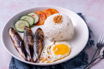Tinapasilog is Tinapa (Smoked Fish), Sinangag (Fried Rice) and Itlog (Egg). Tinapa is a FIlipino term for fish preserved or cooked through the process of smoking them.