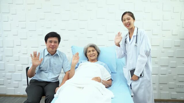 Son of an elderly woman patient Using tablet to record video. Everyone waved goodbye with smiling faces. When the treatment improves to be able to go home.