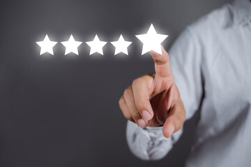 Businessman pointing a five-star symbol to increase the company's rating, customer service and...