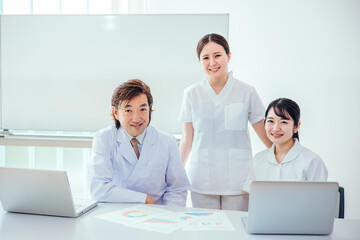 Fototapeta premium ミーティングをする白衣を着た男女（医者・看護師） 