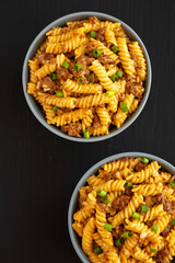 Homemade One-Pot Cheeseburger Pasta in a Bowl on a black surface, top view. Flat lay, overhead, from above.