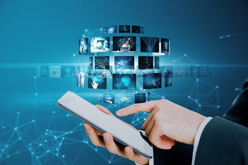 Close up of businessman hand pointing at smartphone with creative digital picture gallery on blue background. Photo album and media technology concept. Switching images.