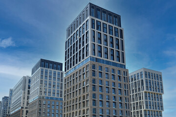 Naklejka premium Exterior of a modern building house object with texture walls and windows. Luxury modern tall block of flats without balconies. Living apartments or office building. Real estate concept.