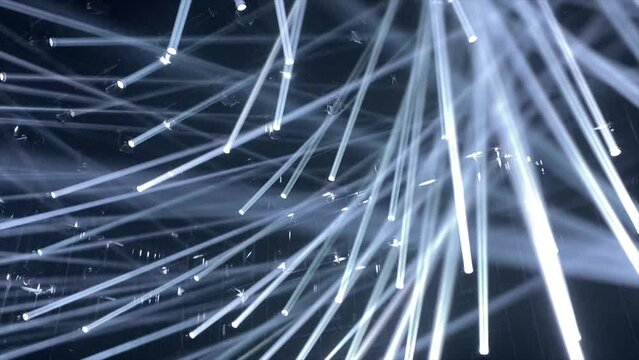 Dozens of sharp white light rays move through a dark black painted room in a club-like setup. An amazing light show and club vibe and party feelings. 
