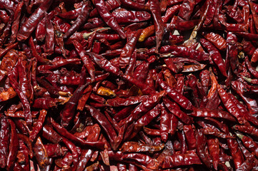 Fototapeta premium Sun-dried chillies . Dried red chilies or cayenne peppers on a bamboo tray. Dried chilies are one of the staple ingredients in Asian cuisine.