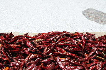 Sun-dried chillies . Dried red chilies or cayenne peppers on a bamboo tray. Dried chilies are one...