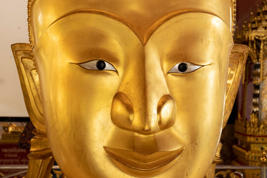 Close up the face of the golden Buddha satue at Wat Phra Thong, Phuket, Thailand.