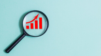 A magnifying glass on a red graph with a rising arrow, Concept of rising prices, Rise in interest rates