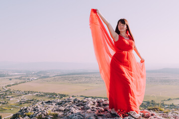 A girl in a red dress on the background of the mountains lifestyle. Illustrating articles about...