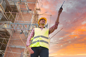 Construction engineers use radios to control work at construction sites. industrial workers wearing...
