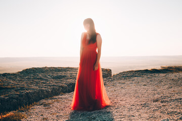 A girl in a red dress on the background of the mountains lifestyle. Illustrating articles about...