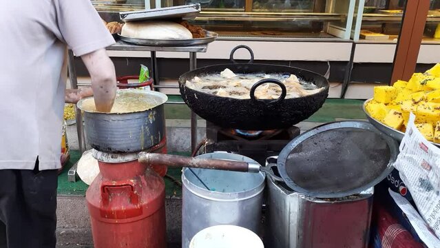 Chef Cooking Flame Frying Pan. Street food fried Samosa. Street food vendor frying samosa in India. 
Samosa Frying in Hot Oil Indian Fast Food - Preparing And Frying Samosa At Ramzan Market.