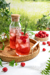 Summer refreshing non-alcoholic cocktails. Raspberry lemonade garnished with fresh rosemary. Summer raspberry beverage with sparkling water. Copy space.