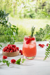 Summer refreshing non-alcoholic cocktails. Raspberry lemonade garnished with fresh rosemary. Summer raspberry beverage with sparkling water. Copy space.