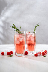 Summer refreshing non-alcoholic cocktails. Raspberry lemonade garnished with fresh rosemary. Summer raspberry beverage with sparkling water. Copy space.
