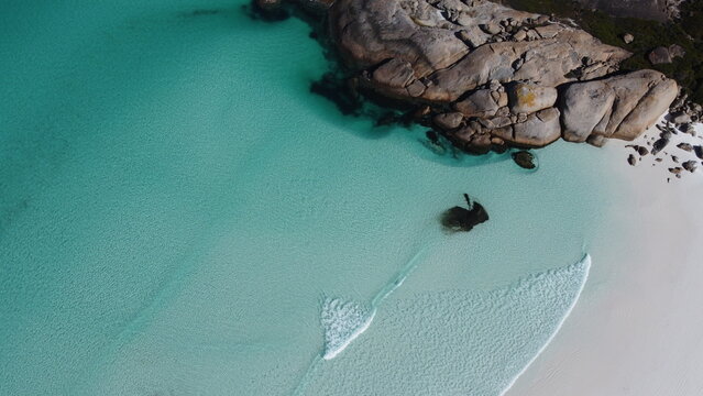 Aerial view, blue shallow water in south-west Australia. Beach in Bremer Bay. Rocks and water. Little foamy waves. Transparent water. Drone picture.