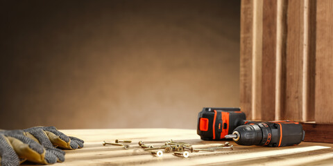 Drill on wooden desk and workshop interior. Free space for your decoration. 