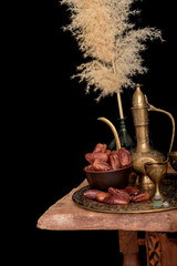 Arabic coffee and dates set up. black background.