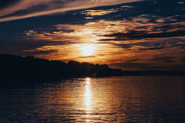 Sunset over the river on a dark summer evening. Beautiful nature background
