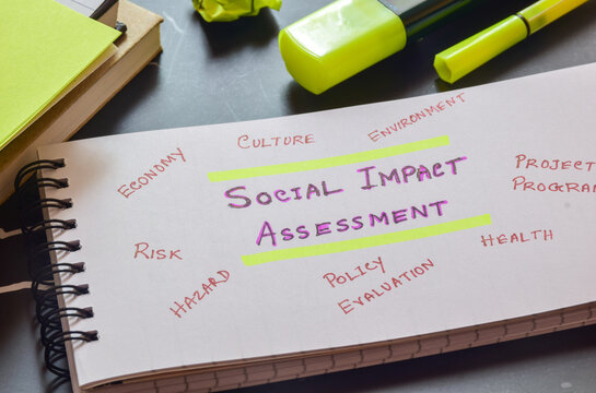 Notepad with the text Social Impact Assessment (SIA) and keywords on desk. Selective focus.