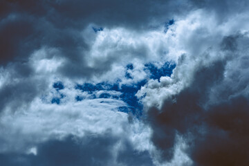 Obraz premium Dark stormy sky is full of dark clouds at night.Bad weather before a big storm rain. Light emission from the Edge of clouds. The surface of a Black haze at close range.Silence before the storm.