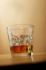 shot of rum in elegant glass on nude-colored surface