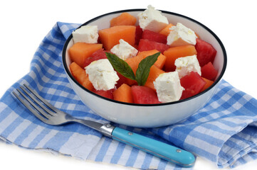 Salade composée avec du melon, de la pastèque et de la feta servie dans une assiette avec une...